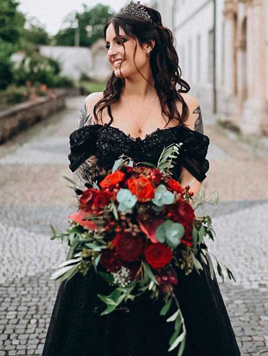 Braut in schwarzem Brautkleid mit rotem Blumenstrauß, echte Hochzeit in der Schweiz